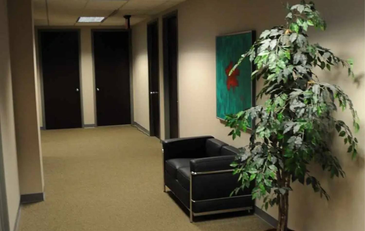Office Corridor with modern decor, seating area, framed artwork, and professional hallway design for workplace use
